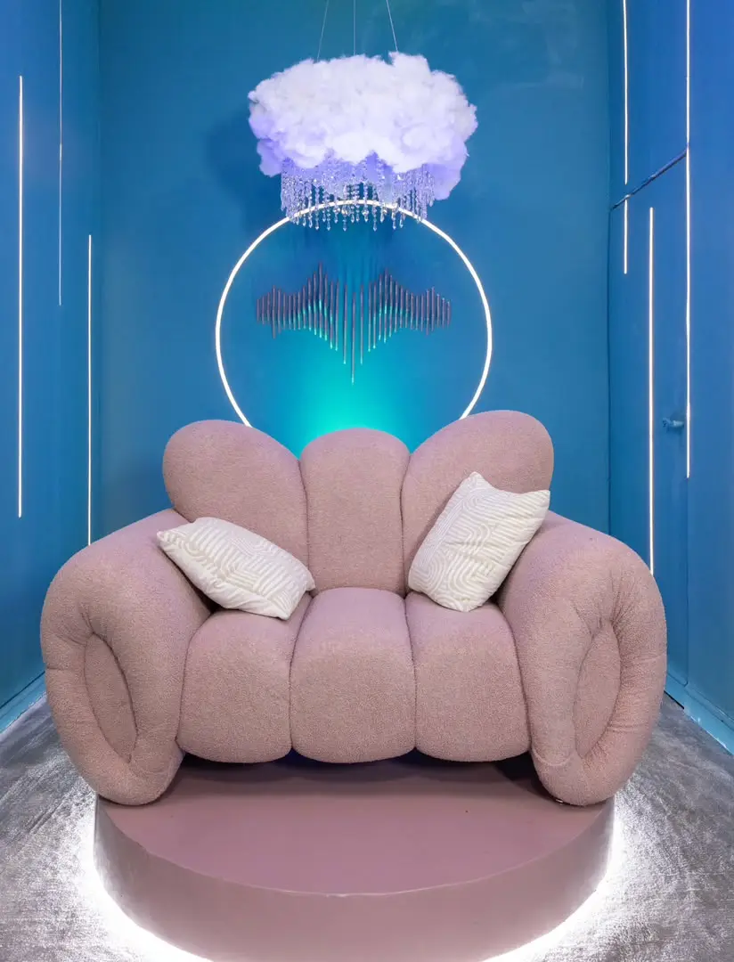 Official Big Brother Naija Season 11 Diary Room featuring a plush pink armchair, illuminated neon halo ring, and cloud chandelier, Credit: Multichoice